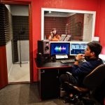young-asian-singer-with-microphone-recording-song-record-music-studio-with-sound-producer_627829-3666
